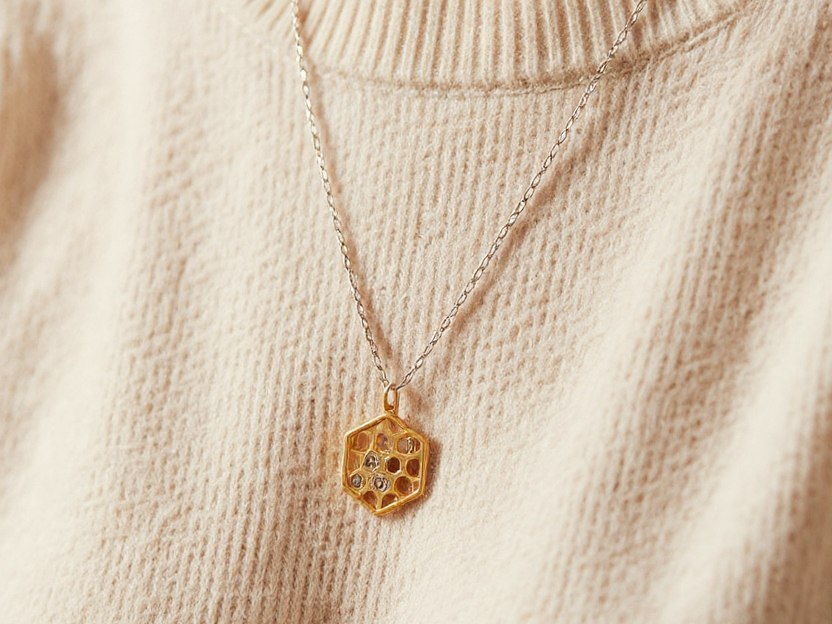 złoty wisior w kształcie plastra miodu na srebrnym łańcuszku